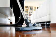 Person vacuuming living room. Maximising independence through rehabilitation.