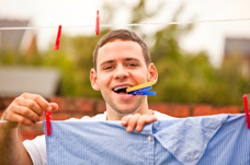 Man hanging laundry on washing line. Promoting independence through Neuro Rehabilitation.